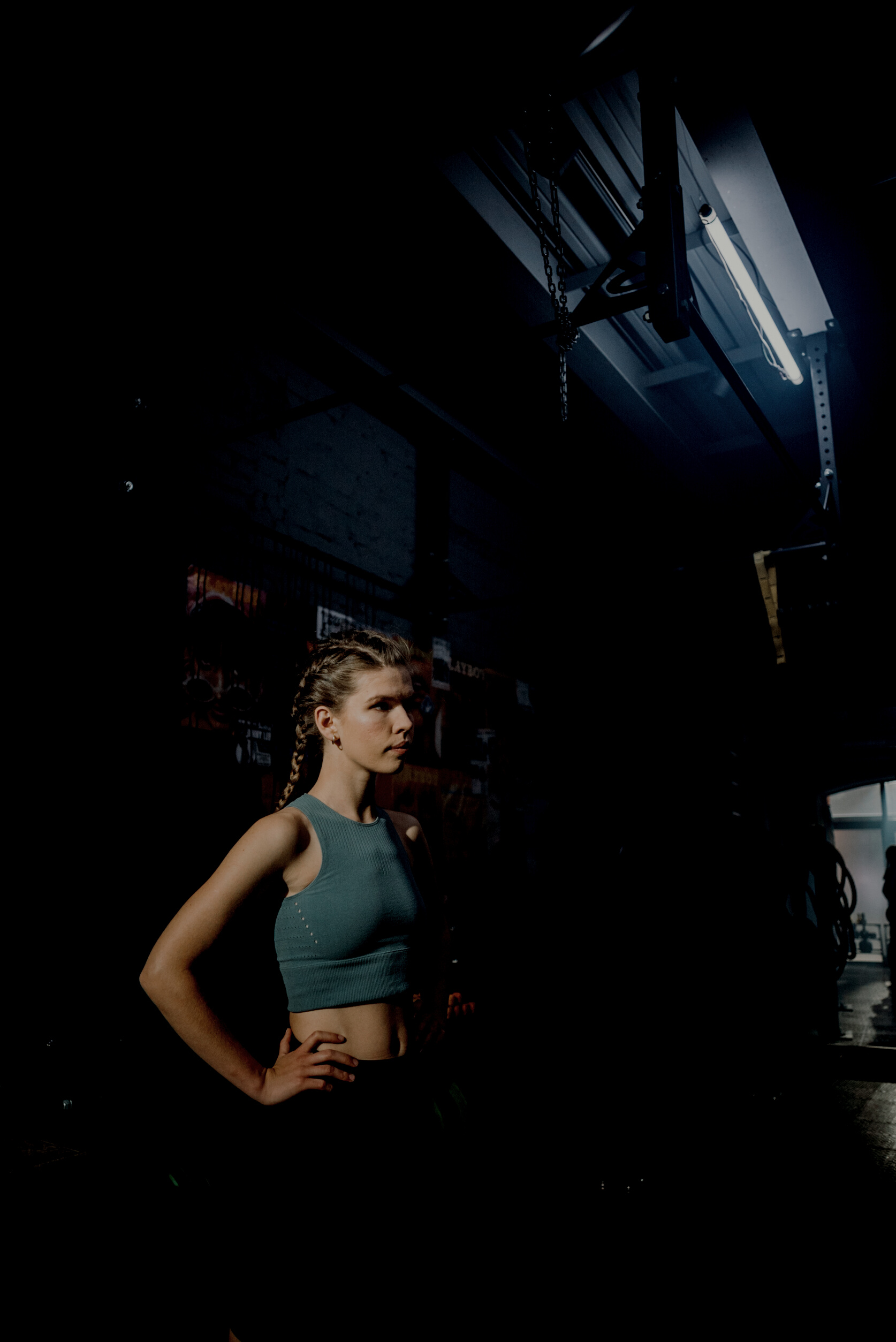 Woman in Gray Tank Top and Brown Shorts Standing in Front of Black and White Wall